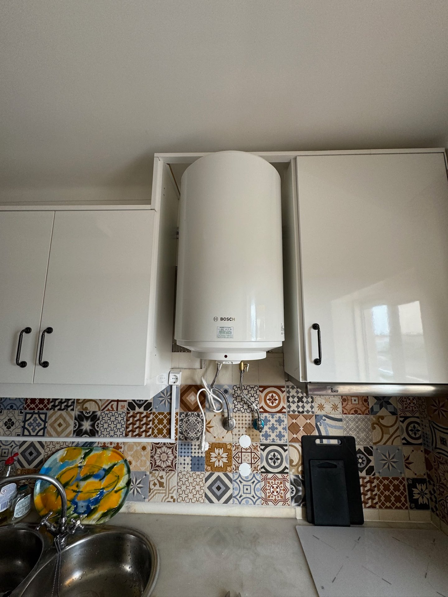 Termoacumulador Bosch integrado entre armários brancos